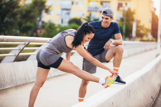 istock Young couple stretching on the bridge 987623174