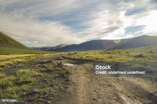 Mongolian Altai Dirt Road And Mountain Valley In Beams Of The Evening Sun Smoking Chimney Of Traditional Yurt Nomads Nature And Travel Mongolia Stock Photo - Download Image Now