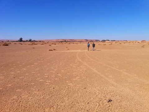 Sahara Desert, Beni Abbes, Bechar, Algeria - November 2, 2017: Two Algerian men are walking on the Sahara Desert.