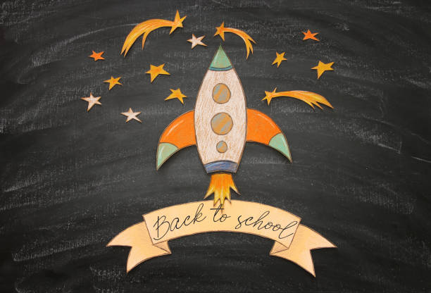 istock Back to school concept. rocket, space elements shapes cut from paper and painted over classroom blackboard background. 987639626