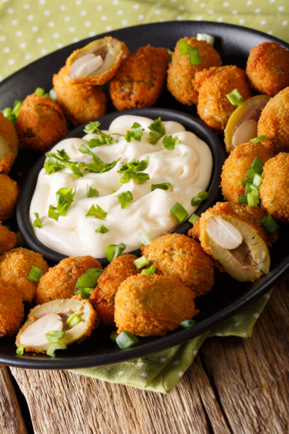 istock Fried olives in breading stuffed with almonds close-up on a plate. vertical 987639946