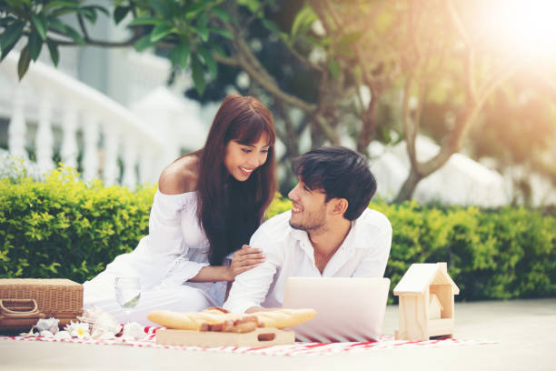 istock Happy Romantic Couples lover talking and drinking wine while having a picnic at home 987640322