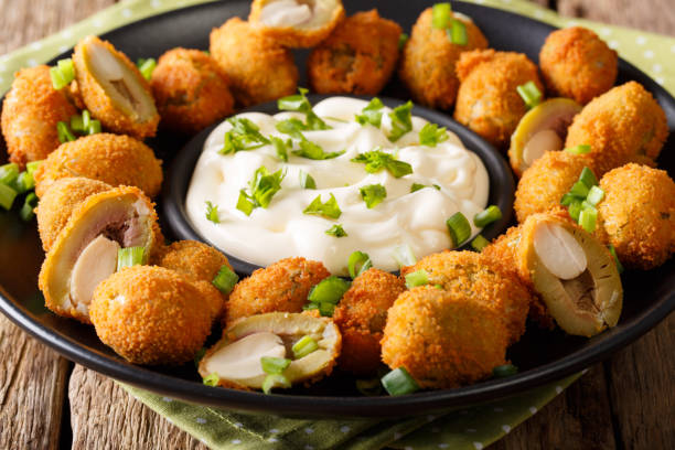 istock Fried olives stuffed with almonds close-up and cream sauce. horizontal 987642576