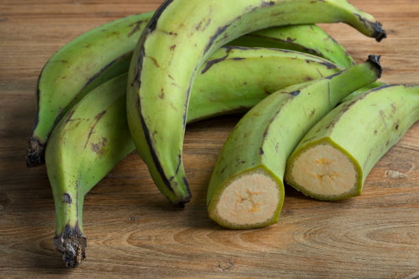 istock Whole and half green unripe bananas 987642694