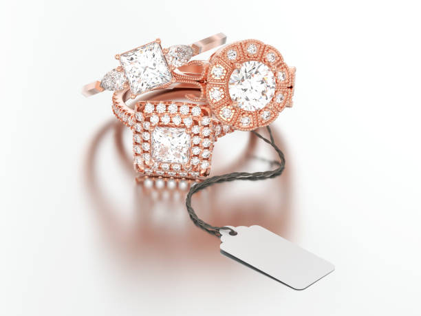istock 3D illustration three different rose red gold engagement diamond rings with rope tag on a grey background 987643916