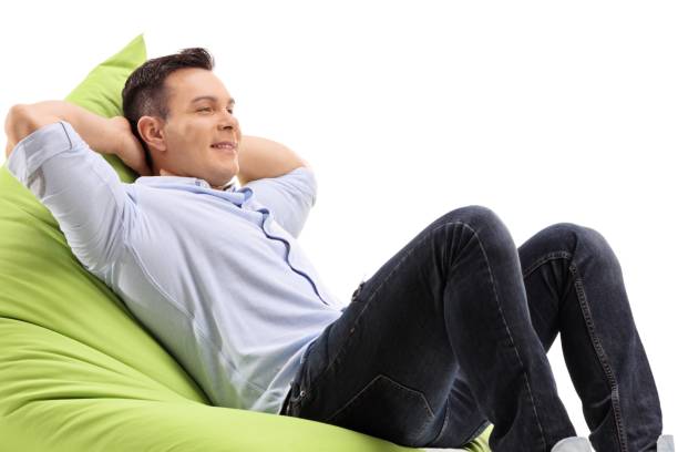 istock Relaxed young man sitting on a beanbag 987648522