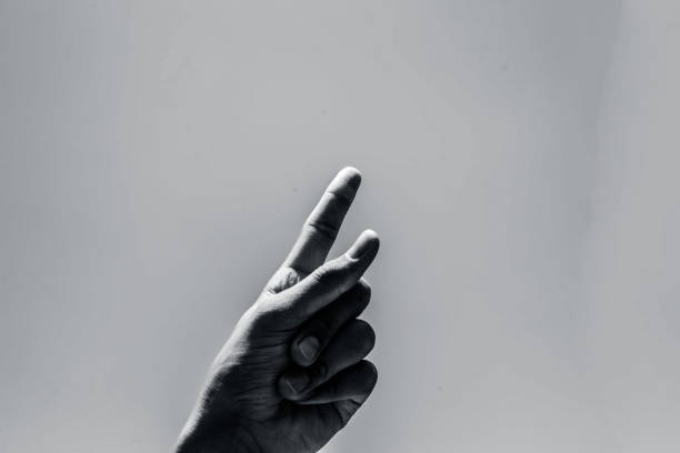 istock Single human finger rising towards the plain blue cloudless sky. 987648680