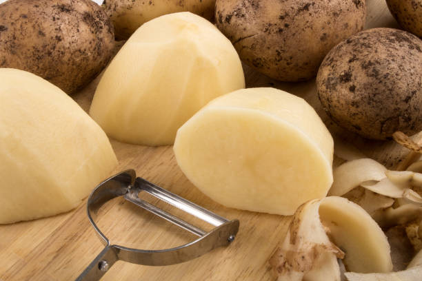 istock raw peeled potatoes on a wooden board 987652222