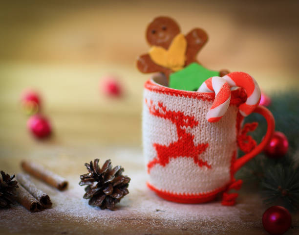 istock Christmas Cup ornament and a fun gingerbread on a wooden table 987681662