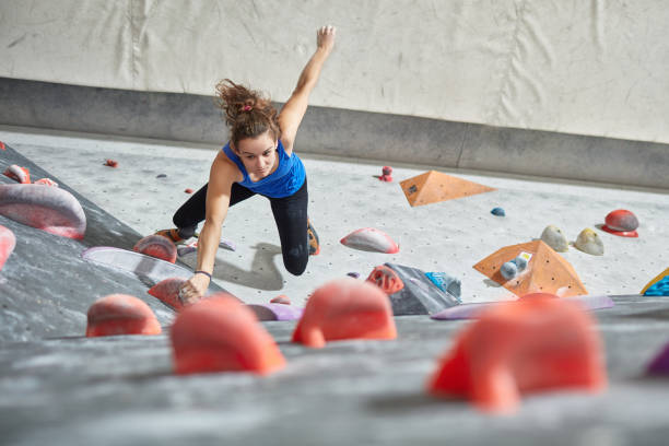 istock Active young woman climbing wall in gym 987698138
