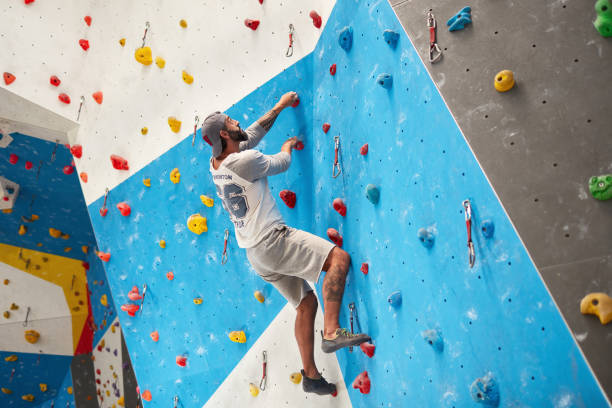 istock Active mature man climbing wall in gym 987701862