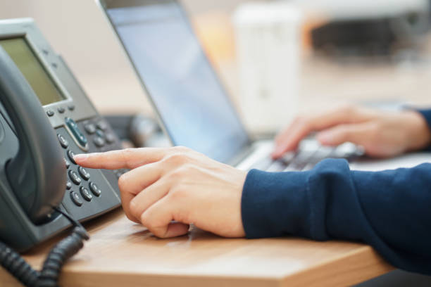 close up man hand point to press button number on telephone office desk.hotline employee concept close up man hand point to press button number on telephone office desk.hotline employee concept voip stock pictures, royalty-free photos & images