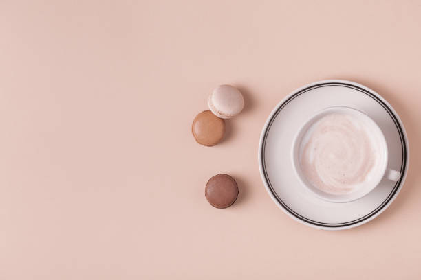 istock Cup of coffee with macaroons on pastel background 987733928