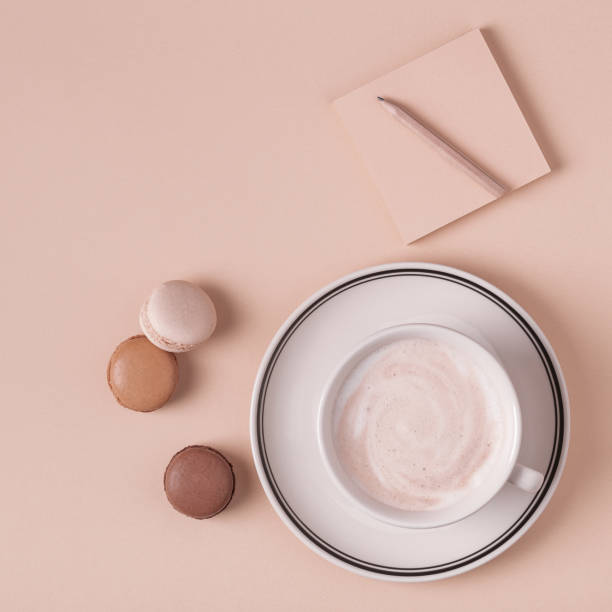 istock Cup of coffee with macaroons on pastel background 987733946