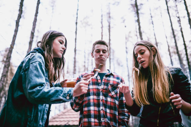 istock Group Of Friends Eating Barbecue Meat During Camping 987735694