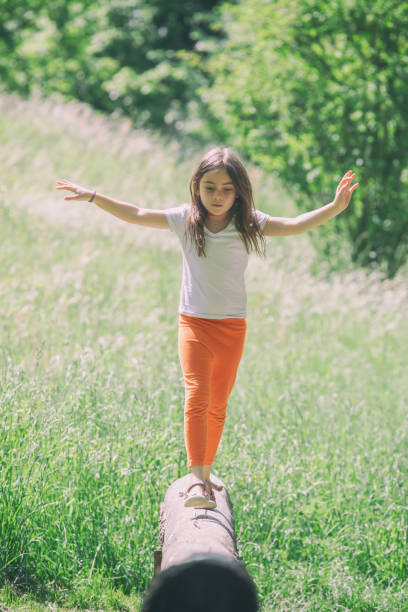 istock Girl balances on a tree trunk 987739222