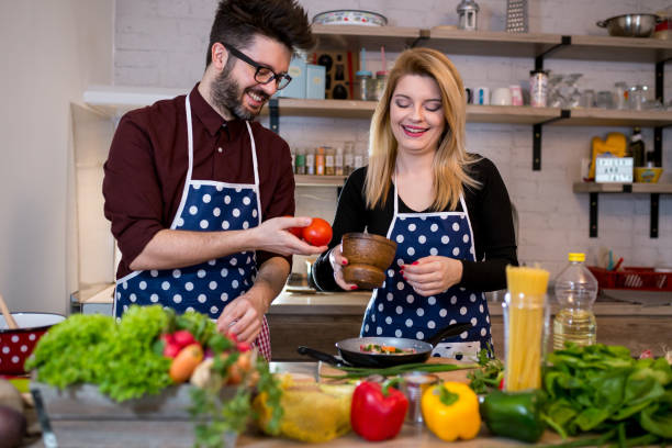 istock Smiling young couple cooking food in the kitchen 987739876