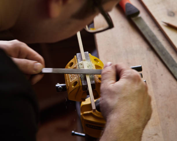 der meister zieht die klammer der klassischen gitarre. produktion der klassischen gitarre. - ruler wood instrument of measurement measuring stock-fotos und bilder