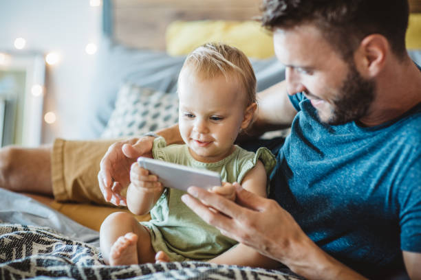 istock Father shows little daughter something on phone 987750684
