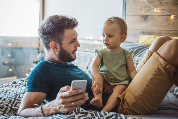 istock Father shows little daughter something on phone 987750752