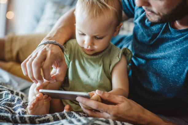 istock Father shows little daughter something on phone 987750924