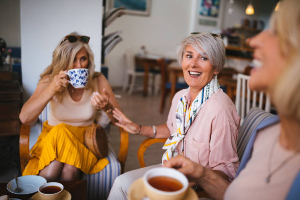 istock Senior women drinking tea and having a conversation at cafe 987754698
