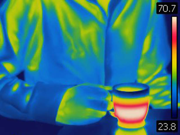 istock Thermal image of man holding hot coffee cup. 987762406