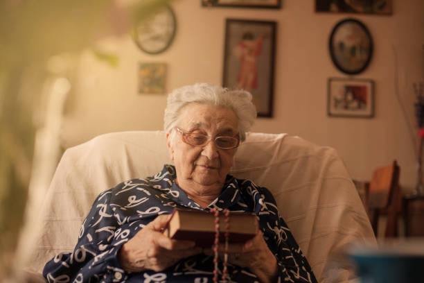Senior woman holding bible and rosary.