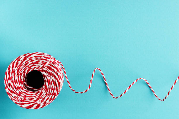 istock red white packing Christmas rope on blue background 987777038