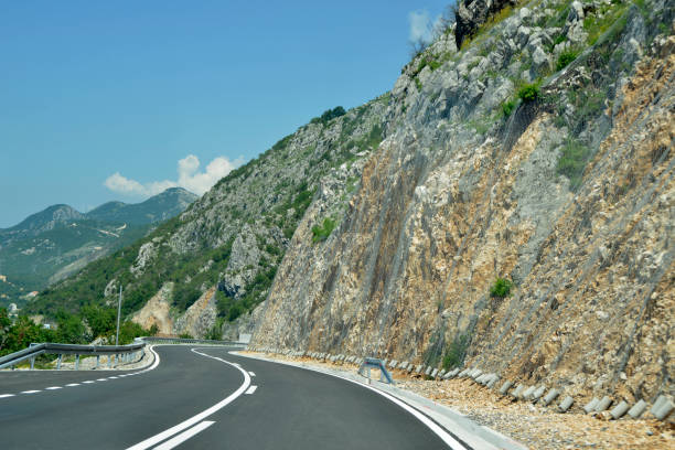 istock Double bend winding road and protective metal net against slops 987781362