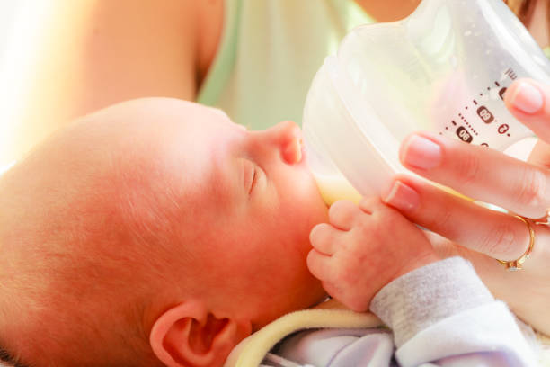 istock Little newborn eating drinking from bottle 987797442