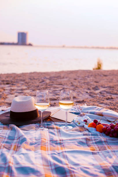 istock Picnic with wine on the beach by the sea. Romantic dinner at sunset. Copy space 987803204
