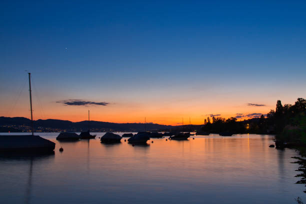 eagerly waiting for the sunrise, the first rays of sun appear behind the mountain peaks of the Swiss Alps