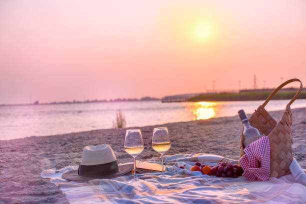 istock Picnic with wine on the beach by the sea. Romantic dinner at sunset. Copy space 987803842