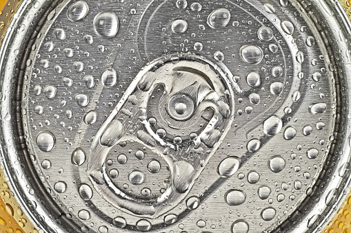 Can of beer in drops of water, as background
