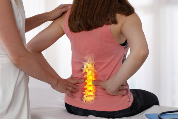 Woman suffering from low back during medical exam. Chiropractic, osteopathy, Physiotherapy. Alternative medicine, pain relief concept. stock photo