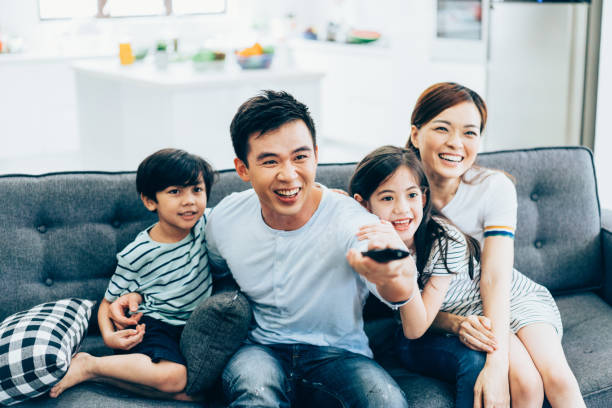 Cheerful asian family watching tv together Cheerful asian family relaxing at home watching tv asian kids watching tv stock pictures, royalty-free photos & images