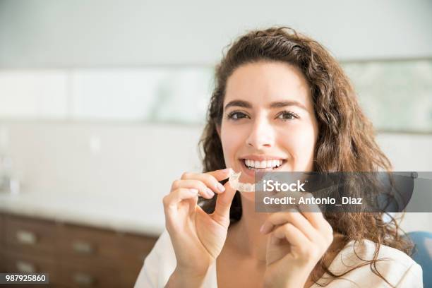 Beautiful Patient Holding Orthodontic Retainers In Dental Clinic Stock Photo - Download Image Now