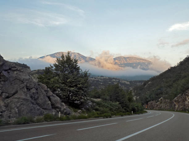 istock Look on the mountain peaks over the clouds from the winding mountain road 987926164