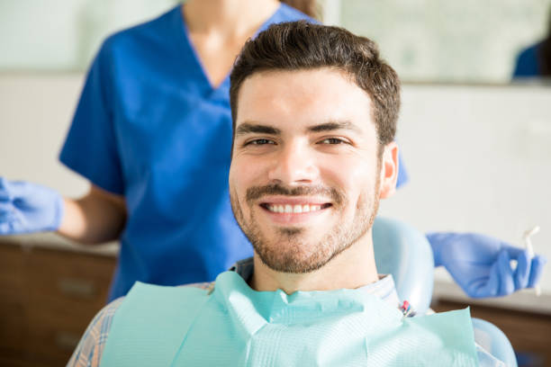 istock Smiling Man With Dentist Holding Dental Tools At Clinic 987930082