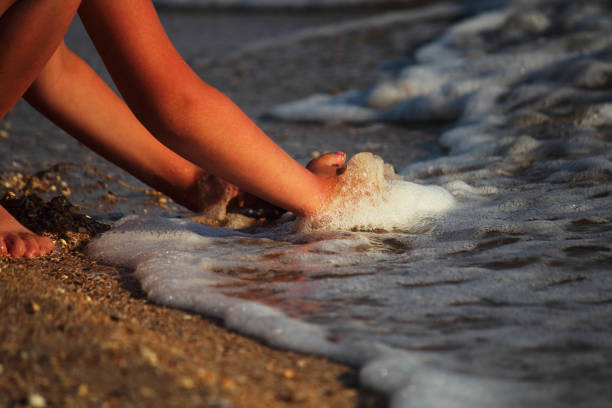 istock Marine background. A child is playing with sand on the beach. Abstract background. Selective focus. Close-up, side view, copy space. 987963526