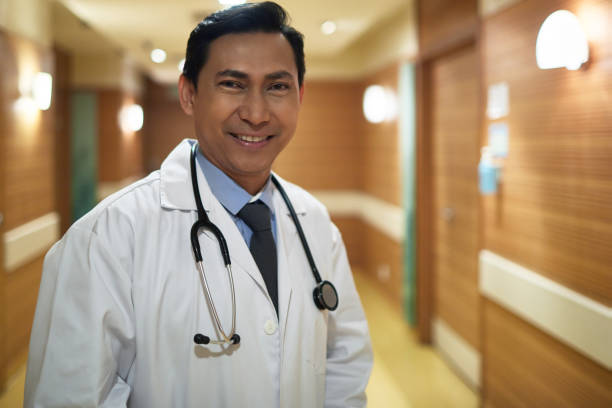 istock Smiling doctor with stethoscope in hospital 987966634