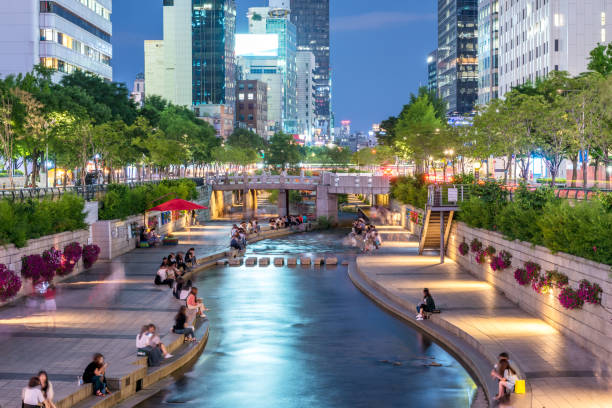 People elaxing by Cheong-Gyecheon stream in the centre of Seoul on a summer evening