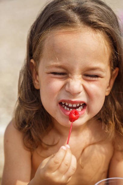 istock Beautiful boy is eating raspberries 987983066