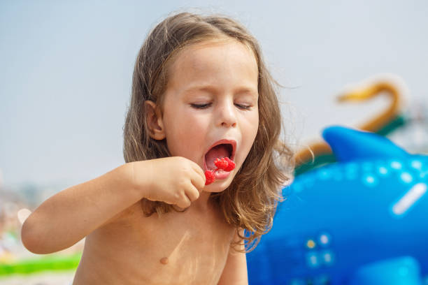 istock Beautiful boy is eating raspberries 987986960