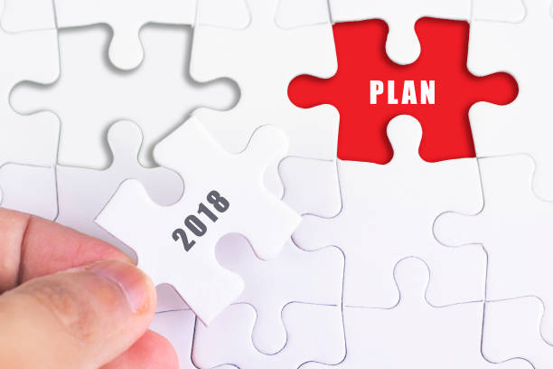 istock Business Concept - Female hand and missing puzzle with 2018 PLAN. 987987860