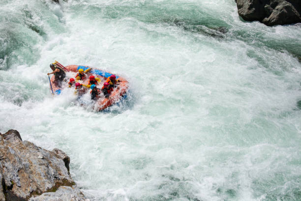 istock Small group of men and women white water river rafting 988017500