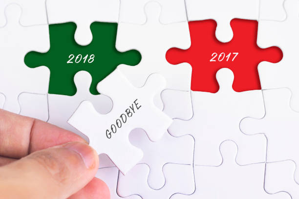 istock Business Concept - Female hand and missing puzzle with GOODBYE 2O17 WORD. 988030174