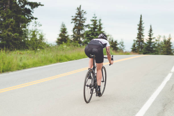 istock Cyclist rides along a rural highway 988059466