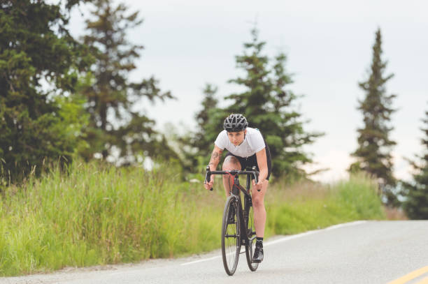 istock Cyclist rides along a rural highway 988059494